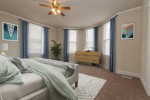 Spacious bedroom in Oaklee Village Apartments, featuring large windows, cozy decor, and modern furnishings.