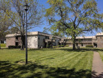 Exterior view of Tivoli Apartments in Virginia Beach, featuring green lawns and well-maintained grounds.