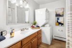 Modern bathroom with in-unit washer, stylish decor, and natural light at Independence Green Apartments.