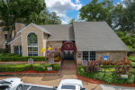 Welcome center entrance of The Park at Via Veneto apartments in Jacksonville, FL, featuring landscaped gardens and signage.