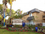Exterior view of Bella Terraza apartments in Jacksonville, featuring a welcoming sign and landscaped gardens.