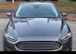 Front view of a 2013 Ford Fusion Titanium AWD in great condition with chrome grille and stylish headlights.