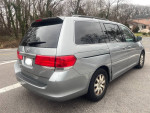 2009 Honda Odyssey minivan in silver, showing exterior dents and sliding door feature.