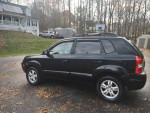 2006 Hyundai Tucson Limited FWD in black, parked in a residential area with trees in the background.
