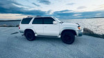 2002 Toyota 4Runner SR5 RWD parked by the water, showcasing its sleek design and well-maintained exterior.