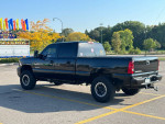 2006 Chevrolet Silverado 1500 truck with aftermarket headlights parked in a lot, showcasing its clean, rust-free body.