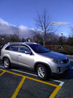 2015 Kia Sorento EX FWD in silver, parked in a lot with trees in the background, showcasing excellent condition.