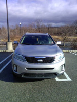 Front view of a 2015 Kia Sorento EX in silver color parked outside, showcasing its stylish design.