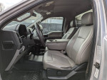 Interior view of a 2018 Ford hook lift truck with leather seats and modern dashboard design.