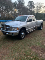2005 Dodge Ram 3500 Laramie work truck with strong engine and 4wd, seen in grassy setting.
