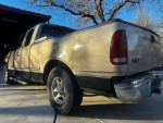 1998 Ford F150 pickup truck with original 87,000 miles, showing wear and a damaged front fender.