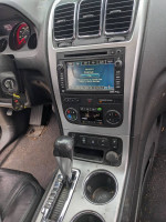 Interior view of a 2012 GMC Acadia SLT with a modern dashboard and audio controls.