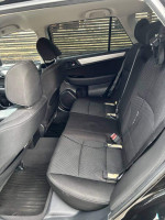 Interior view of a 2017 Subaru Outback 2.5i showing backseat with black fabric and spacious layout.