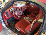 Interior view of a 2008 Porsche Boxster RS 60 Spyder with luxurious red leather seats and silver accents.