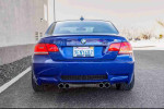 Rear view of a 2008 BMW M3 in Interlagos Blue, showcasing dual exhaust and sleek design.
