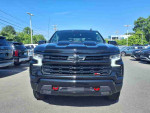 Front view of a 2022 Chevrolet Silverado 1500 Limited Custom Trail Boss, black exterior, on display with nearby vehicles.