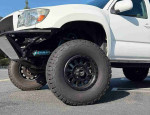 Close-up of a modified 2020 Toyota Tacoma SR with off-road tires, showcasing its rugged capabilities.