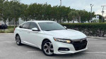 2018 Honda Accord EX-L in white, showcasing its stylish design and sporty profile in a parking lot.