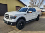 White 2015 Ford F150 truck parked outside, showcasing its rugged design and sleek features.