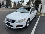 2009 Volkswagen CC Luxury Sedan in white, showcasing its sleek design, parked outdoors with tinted windows.