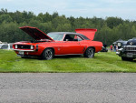 1969 Chevrolet Camaro SS in Hugger orange with black stripes, showcased at a car event.