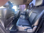Interior view of a 2015 Ford F350 Lariat dually truck, featuring leather seats and spacious rear seating.