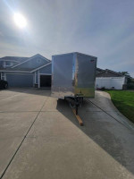 2024 24 ft enclosed box trailer for sale, double axle, with enhanced features, parked in residential driveway.