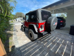 2006 Jeep Wrangler Sport 4WD parked in driveway, showcasing its iconic design and off-road capabilities.