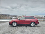 2015 Subaru Outback parked on a scenic overlook, featuring new snow tires and a clean black interior.