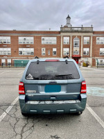 Rear view of a 2011 Ford Escape XLT parked in front of a school, showing its condition and features.