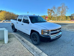 2010 Chevrolet Silverado 1500 LT 4WD crew cab in white parked outside, showcasing its features and clean design.