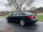 2013 Mercedes Benz C300 4MATIC in black, parked on a driveway with autumn leaves.