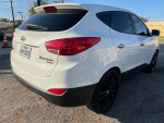 White 2011 Hyundai Tucson with black rims, featuring a clean title and low mileage.
