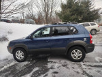 2005 Hyundai Tucson 4x4 parked in snow, equipped with Bluetooth stereo and backup camera.