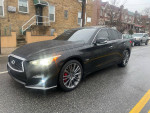 2018 Infiniti Q50 Red AWD parked on the street, featuring clean design and shiny wheels.