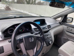 Interior view of a 2011 Honda Odyssey EX with controls and dashboard, low mileage, reliable family van.