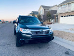 Front view of a well-maintained 2010 Subaru Forester in black, parked on a residential street.