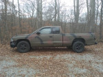 1997 Dodge Dakota Sport 4WD truck parked in a wooded area with camouflage paint.