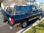 1996 Ford Bronco Eddie Bauer in midnight blue, 4WD with 133,000 miles, parked in a residential area.