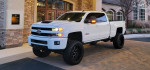 2019 Chevrolet Silverado 2500 Duramax L5P with a 7-inch lift and custom wheels parked outside a building.