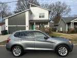 2014 BMW X3 xDrive28i AWD parked in front of a modern house with no visible damage, showcasing its sleek design.