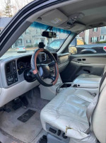 Interior view of a 2001 Chevrolet Suburban with clean dashboard and captain seats.