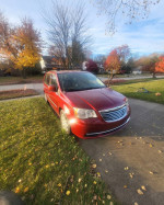 2014 Chrysler Town & Country Mini Van parked on a lawn with autumn foliage, showcasing its good condition and clean title.