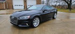 2018 Audi A5 Premium Plus coupe in black, showcasing sleek design and premium features, parked outdoors.