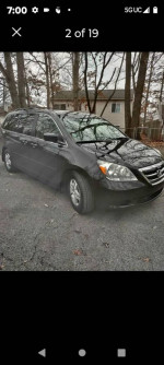 2006 Honda Odyssey Touring FWD in black parked, featuring leather seats and power sliding doors.