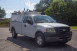 2008 Ford F150 commercial truck with cap, ideal for contractors, parked in a lot with clear sky