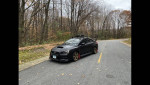 2015 Subaru WRX Limited AWD parked on a road surrounded by trees, showcasing its black dip finish and aftermarket wheels.