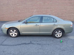 2009 Ford Fusion in green color, side view, with dent on the back, available for test drive.