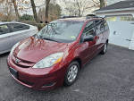 2010 Toyota Sienna LE 7-Passenger in excellent condition, parked in driveway with alloy wheels and red exterior.