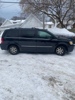 2009 Chrysler Town & Country minivan parked in snow, showing a reliable vehicle with 153k miles.